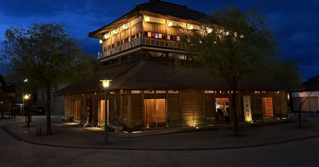 夜にライトアップされた木造建築の芝居小屋