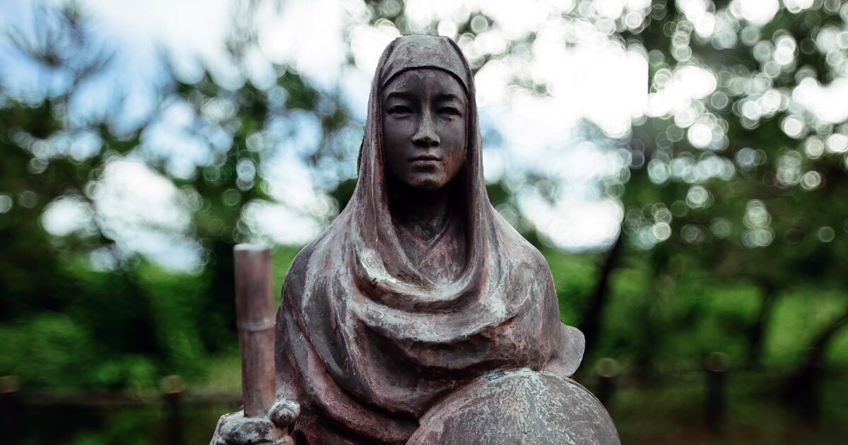 自然の中に佇む尼僧の銅像のクローズアップ