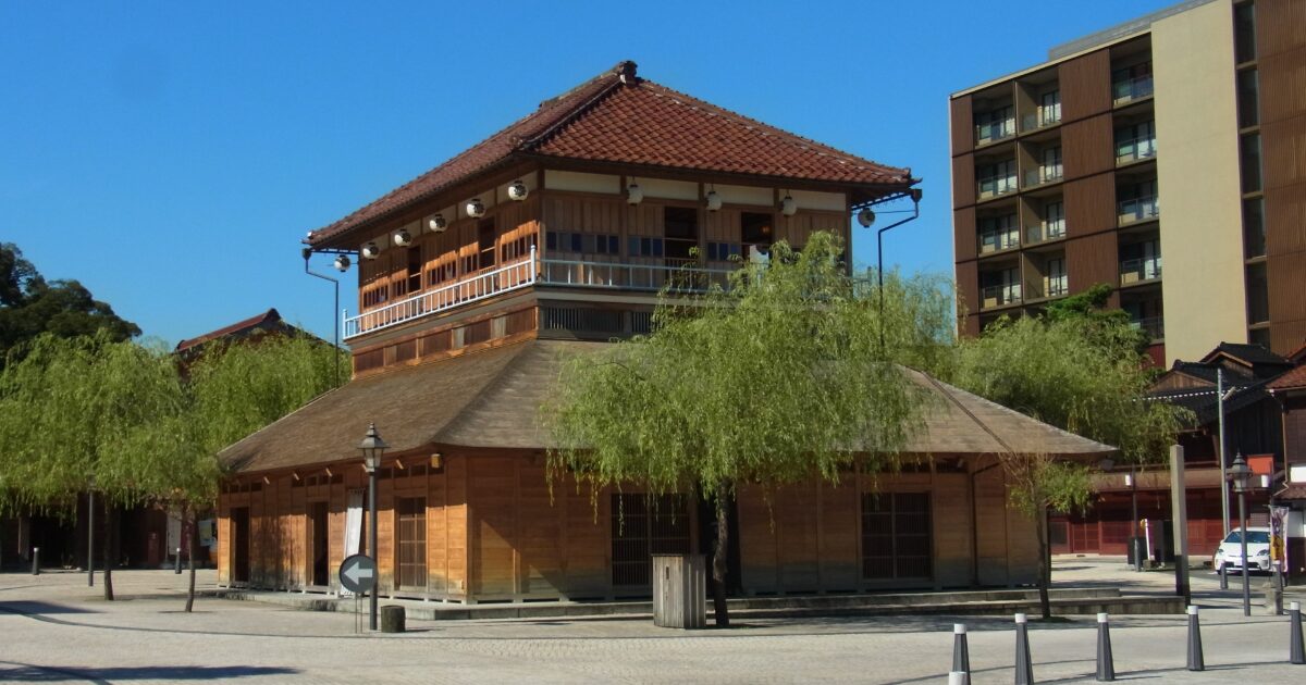 青空の下に建つ木造の山中座外観