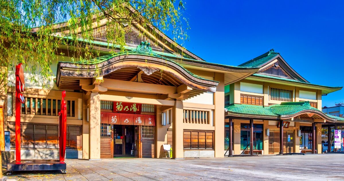 青空の下に佇む山中温泉の菊の湯外観
