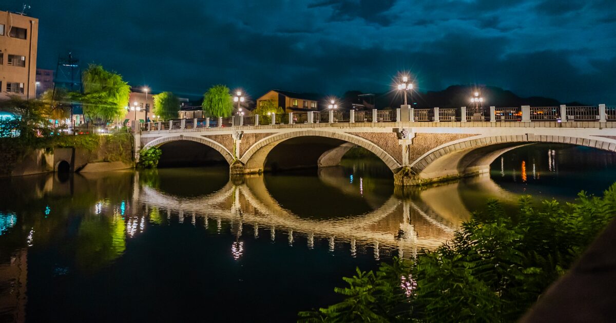 夜の中の橋爪橋と浅野川の水面に映るアーチ
