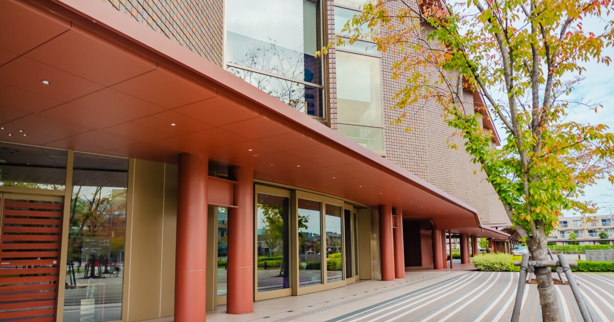 金沢21世紀美術館の現代的な建物と紅葉の木々