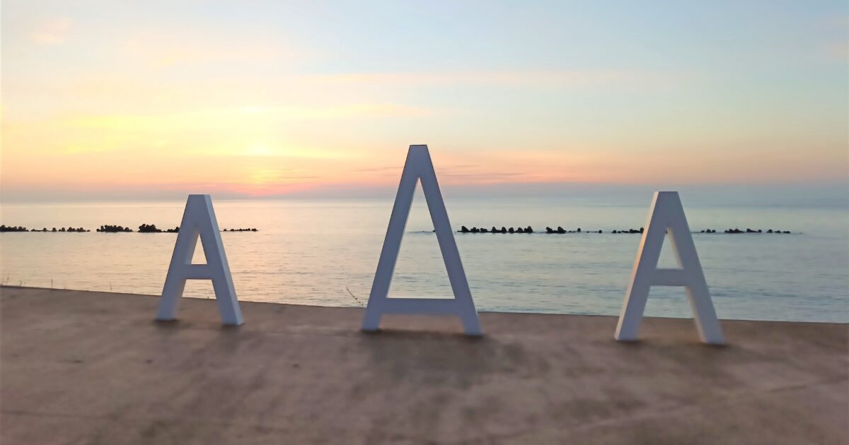夕日に染まる日本海とAAAモニュメント
